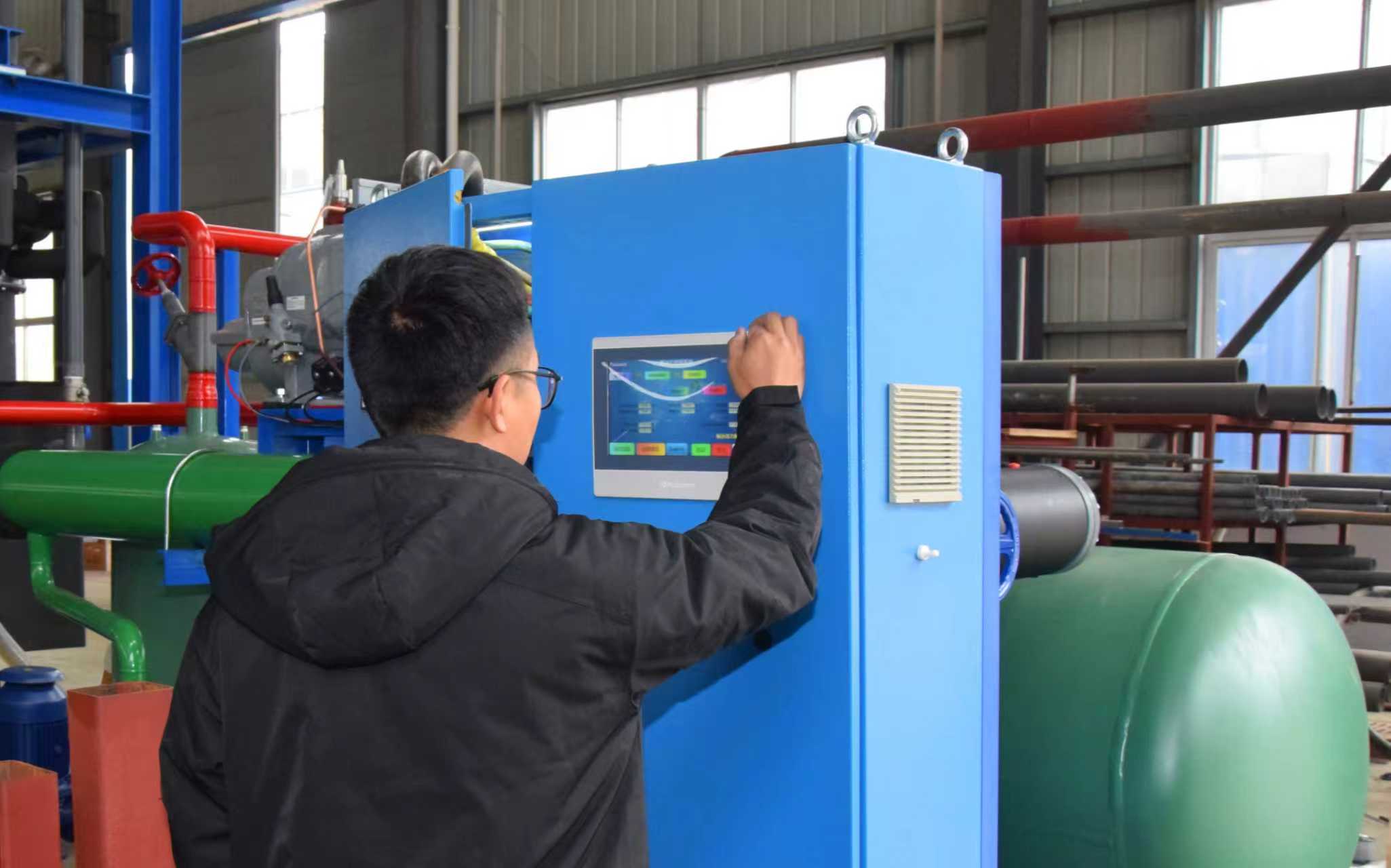 Engineer operating PLC control system on Focusun tube ice machine for intelligent and automated ice production